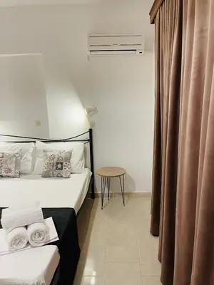 a hotel room with two beds and a table at Anastasia Apartment in Afantou