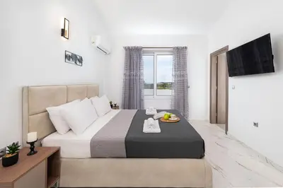 a bedroom with a bed with a tray of fruit on it at Villa Nikoli in Kolimbia