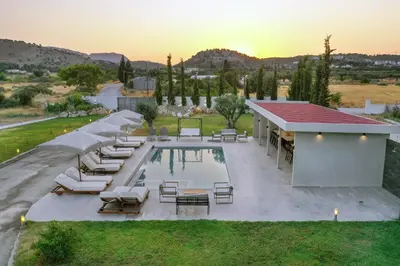 an overhead view of a swimming pool with lounge chairs and a pool at Villa Nikoli in Kolimbia