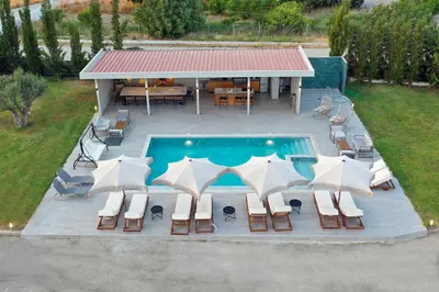 an overhead view of a swimming pool with chairs and umbrellas at Villa Nikoli in Kolimbia