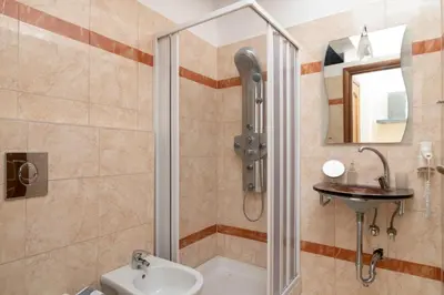a bathroom with a shower and a toilet and a sink at Ibiscus and Lily Apartments in Rhodes Town