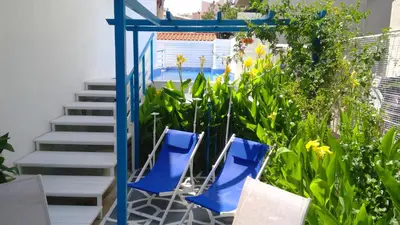 two blue chairs in a garden with stairs at Ibiscus and Lily Apartments in Rhodes Town