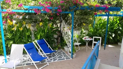 a group of chairs and a table and flowers at Ibiscus and Lily Apartments in Rhodes Town