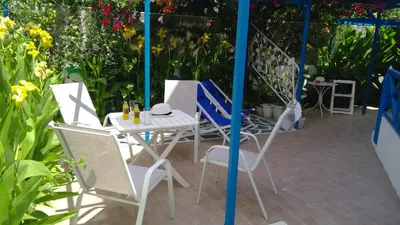 a patio with a table and chairs and flowers at Ibiscus and Lily Apartments in Rhodes Town