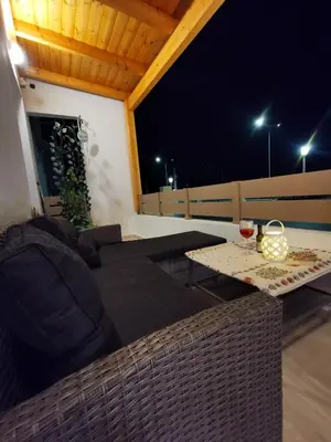a couch and a table on a balcony at night at Blue View Zefiros in Rhodes Town