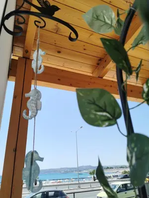 a porch with a wooden roof with a view of the ocean at Blue View Zefiros in Rhodes Town