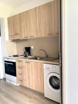 a kitchen with a washing machine and a dishwasher at Elena villa-apartments in Asklipiḯon