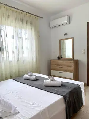 a bedroom with a large bed with two towels on it at Elena villa-apartments in Asklipiḯon