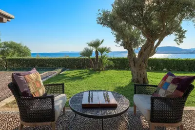 a patio with a table and two chairs and a tree at Aquavisionaire Beach Front Villa in Líndos