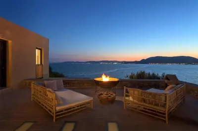a fire pit on a patio with a view of the water at Aquavisionaire Beach Front Villa in Líndos