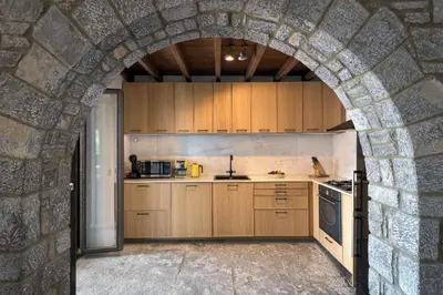 a kitchen with an archway in a stone wall at Aquavisionaire Beach Front Villa in Líndos
