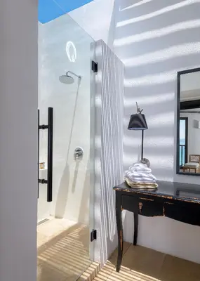 a room with a mirror and a table with a lamp at Aquavisionaire Beach Front Villa in Líndos