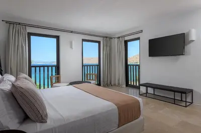 a hotel room with a bed and a television at Aquavisionaire Beach Front Villa in Líndos