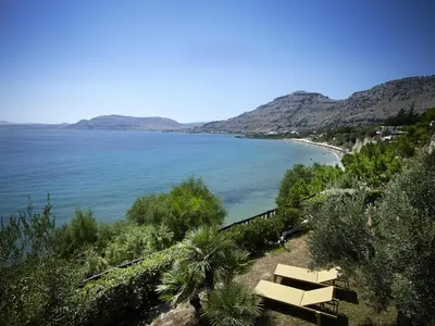 a bench sitting on a hill next to a beach at Aquavisionaire Beach Front Villa in Líndos