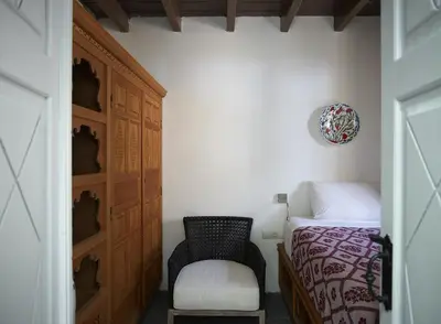 a bedroom with a bed and a chair in a room at Aquavisionaire Beach Front Villa in Líndos