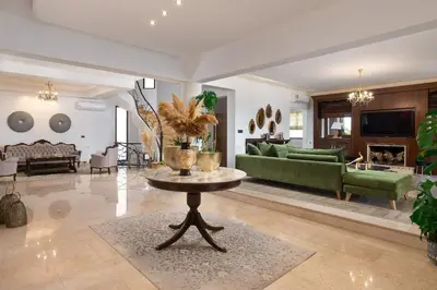 a living room with a green couch and a table at Vento Imperiale Estate in Rhodes Town
