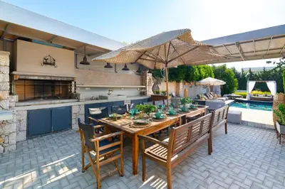 a patio with a table with chairs and an umbrella at Vento Imperiale Estate in Rhodes Town