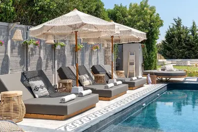 a group of chairs and umbrellas next to a pool at Vento Imperiale Estate in Rhodes Town