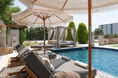 a pool with chairs and umbrellas next to a swimming pool at Vento Imperiale Estate in Rhodes Town