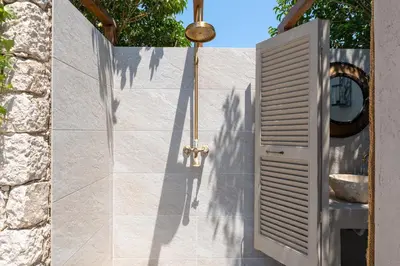 a bathroom with a door and a stone wall at Vento Imperiale Estate in Rhodes Town