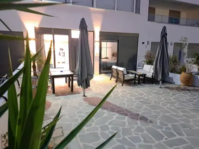 a patio with umbrellas and a table at Courtyard Luxury Suites “ APOSTOLOS” in Pefki Rhodes