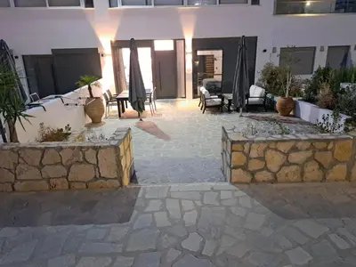 a courtyard with a stone wall and some plants at Courtyard Luxury Suites “ APOSTOLOS” in Pefki Rhodes