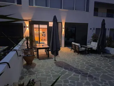 a patio with umbrellas and a table and chairs at Courtyard Luxury Suites “ APOSTOLOS” in Pefki Rhodes