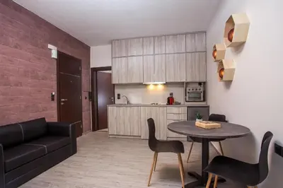 a living room with a table and chairs and a kitchen at Oleana City Center in Rhodes Town