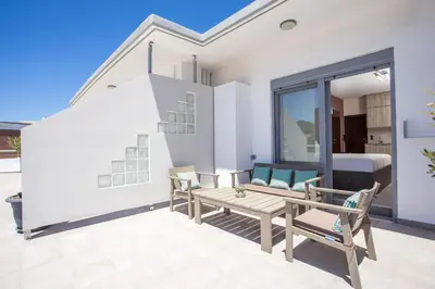 a patio with a table and chairs and a bed at Oleana City Center in Rhodes Town