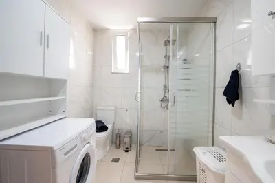 a bathroom with a shower and a washing machine at George's Paradise in Afantou