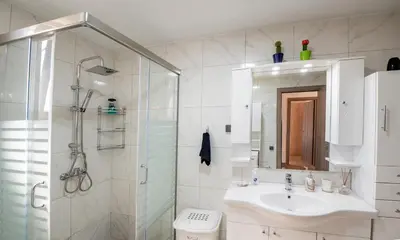 a white bathroom with a sink and a shower at George's Paradise in Afantou