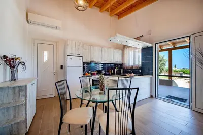 a kitchen with a glass table and chairs and a counter at George's Paradise in Afantou