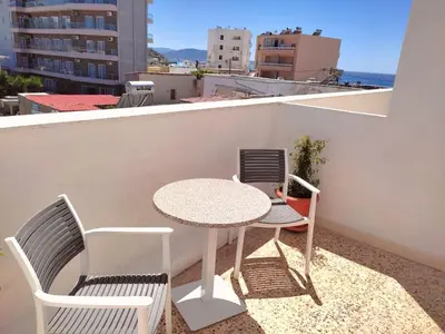 a table and chairs on a balcony with a view of the ocean at Small apartment (studio) in town with sea view in Rhodes Town