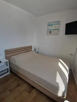 a bedroom with a bed and a flat screen tv at Small apartment (studio) in town with sea view in Rhodes Town