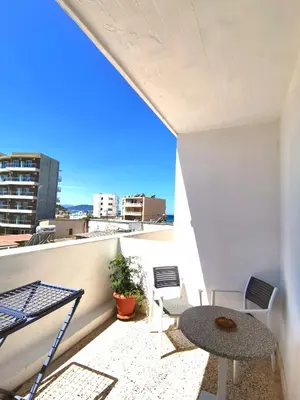 a balcony with a table and chairs on a building at Small apartment (studio) in town with sea view in Rhodes Town