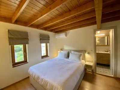 a bedroom with a large white bed in a room at Greenview Maisonnette in Apóllona