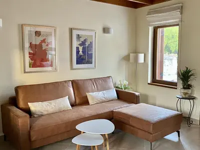 a living room with a brown couch and a table at Greenview Maisonnette in Apóllona