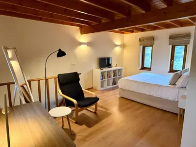 a bedroom with a bed and a chair and a table at Greenview Maisonnette in Apóllona