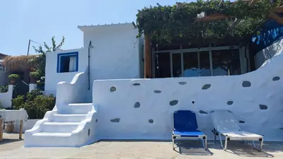 a house with two chairs and a climbing wall at Stegna Rita's apartment in Archangelos