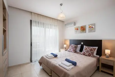 a bedroom with a large bed with towels on it at Blue Wave Villa - road view in Gennadi