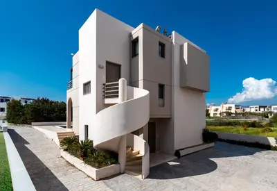a white house with a staircase on the side of it at Blue Wave Villa - road view in Gennadi