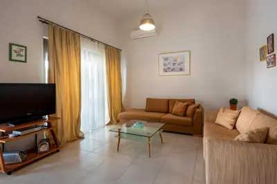 a living room with a couch and a tv at Blue Wave Villa - road view in Gennadi