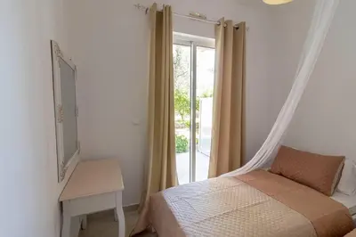 a bedroom with a bed and a window with a mirror at Fotis house in Afantou