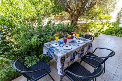 a table with four chairs and drinks on it at Fotis house in Afantou