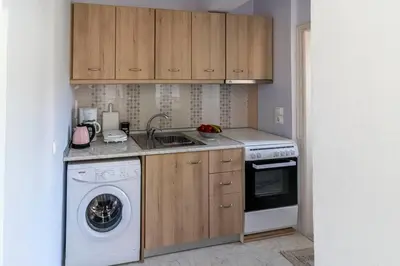 a kitchen with a sink and a washing machine at Fotis house in Afantou