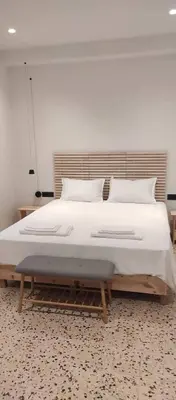 a bedroom with a large bed with white sheets and pillows at Casa Manny in Rhodes Town