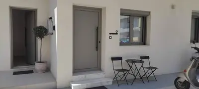 a white building with chairs and a door and windows at Casa Manny in Rhodes Town
