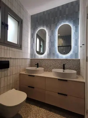 a bathroom with two sinks and two mirrors at Casa Manny in Rhodes Town