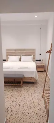 a bedroom with a large white bed and a tripod at Casa Manny in Rhodes Town