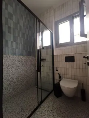 a bathroom with a toilet and a glass shower at Casa Manny in Rhodes Town
